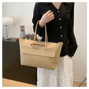 Detail of minimalist beige tote bag showing high-capacity design and ergonomic cutout handle