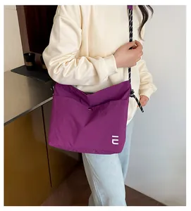Détail du sac bandoulière en nylon violet imperméable avec sangle en corde et boucle
