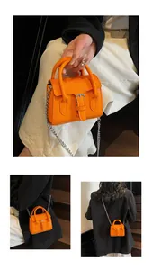 Detail of bright orange micro handbag with silver chain strap and top handle