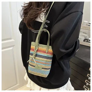 Détail macro du sac cabas en tricot multicolore avec anse en cuir vert clair et logo