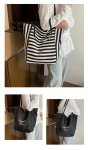 Détail d'un grand sac fourre-tout rayé et d'un sac à bandoulière noir en nylon pour femme