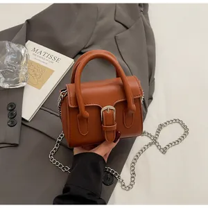 Close-up of caramel brown vintage square bag with silver hardware and chain strap