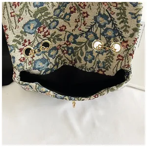 Detail of floral tapestry handbag showing intricate weaving and gold metal hardware