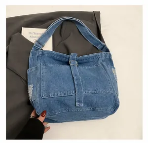 Close-up of vintage blue denim tote bag featuring stylish distressed frayed edge details