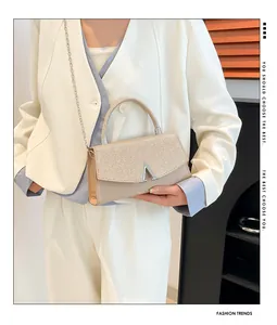 Pochette de soirée champagne avec logo V en métal et poignée ronde pour tenue chic