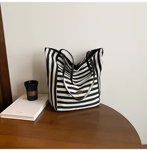 Sac cabas minimaliste en toile à rayures noires et blanches avec logo en métal ovale
