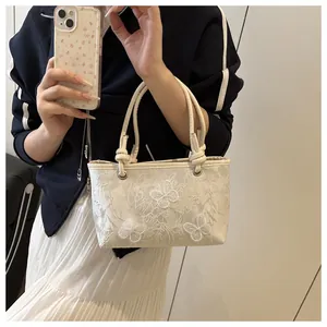 Detail view of 3D butterfly embroidery and lace texture on white bucket bag