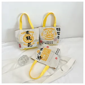 Detailed view of canvas tote bags featuring traditional Chinese calligraphy and yellow handles