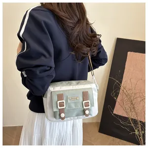 Detail van canvas crossbodytas met groene flap en schattige patch met een konijn