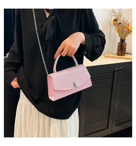 Gros plan sur le sac de soirée rose pailleté avec boucle en V argentée et chaîne