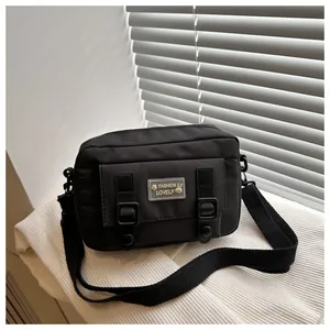 Detail van zwarte canvas crossbodytas met een voorvak met klep en schattige konijn patch