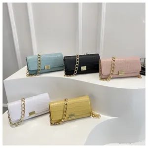 Detail of five croc-embossed shoulder bags with gold chain straps in multiple colors