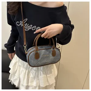 Denim Boston bag with brown leather handles worn by model in casual street style outfit