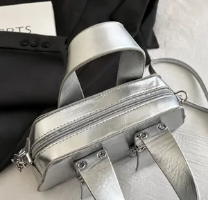 Detailansicht der silbernen Punk-Handtasche mit Reißverschluss und Doppelgriffen