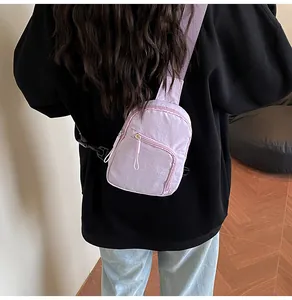 Sac de poitrine en nylon lilas porté en bandoulière dans un décor de style de vie