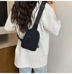 Vue arrière d'un mannequin portant un sac à bandoulière en nylon noir avec sangle