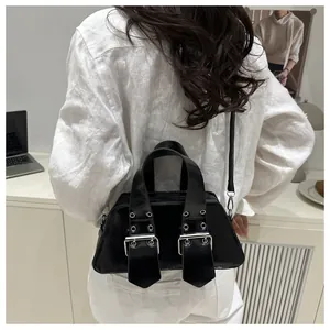 Detail der schwarzen glänzenden Handtasche mit Nietengurt und silbernen Schnallen