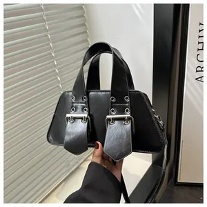 Detailed view of black punk bag with silver eyelets and wide industrial shoulder strap