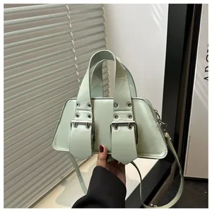 Detail of mint green punk handbag featuring stylish wide leather straps and metal buckles