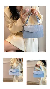 Close-up of the light blue marbled texture and knot detail on the square handbag