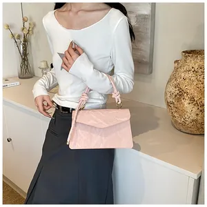 Detail of pink small square bag featuring unique crinkled texture and knotted handle