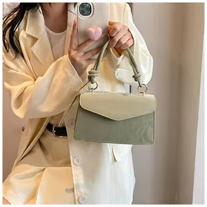 Detail of light green crossbody bag with knotted handle and pleated leather texture