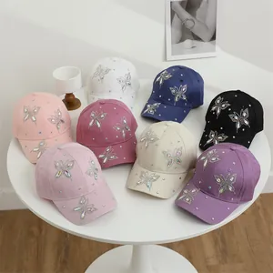 Dettaglio dei cappellini da baseball con farfalle di strass in otto colori differenti