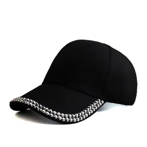 Detail of silver rivets on the brim of a black cotton baseball cap for streetwear fashion