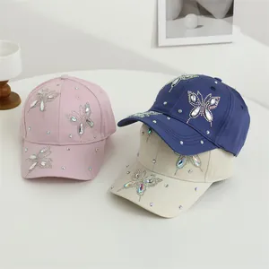 Vista dettagliata dei cappellini rosa, blu e beige con farfalla di strass luccicanti