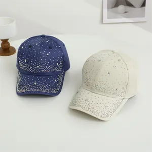 Detailansicht der glitzernden Strasssteine und Metallsterne auf zwei Baseballkappen