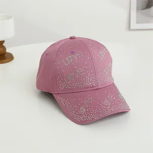 Détail des lettres LOVE en strass brillants sur une casquette de baseball rose femme
