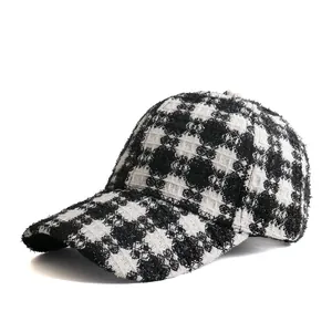 Close-up of black and white houndstooth plaid pattern on a tweed baseball cap