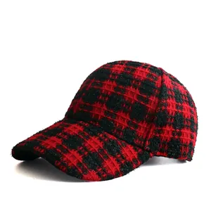 Close-up of red and black plaid tweed texture on a stylish winter baseball cap