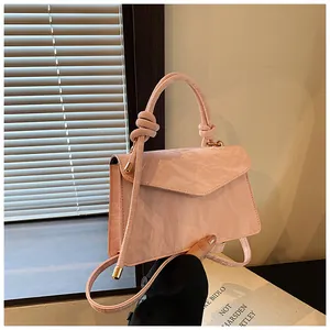 Detailed view of pink crossbody bag with knot handle and artistic pleated texture