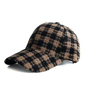 Detailed view of the woven tweed texture on a vintage brown plaid baseball cap
