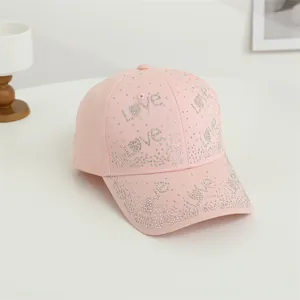 Détail de la casquette rose avec strass brillants et inscription LOVE scintillante