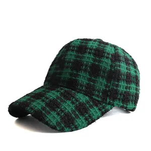 Close-up of winter green and black tweed plaid baseball cap with warm wool texture