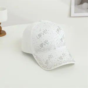 Détail de casquette blanche avec motifs scintillants de lettres Love en strass