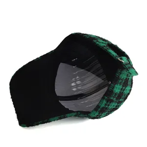 Detail view of green and black plaid tweed baseball cap showing interior and buckle