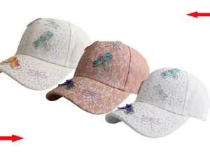 Detailed close-up of lace mesh fabric and sparkling dragonfly rhinestone baseball caps