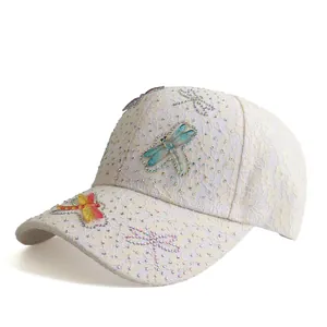 Detailed view of intricate lace texture and colorful rhinestone dragonfly on the hat