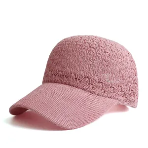 Detailed close-up of pink knit baseball cap featuring crochet leaf pattern and mesh design