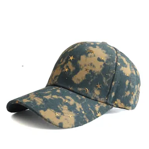 Detail of blue and beige tie-dye baseball cap with gold star and moon metal charms