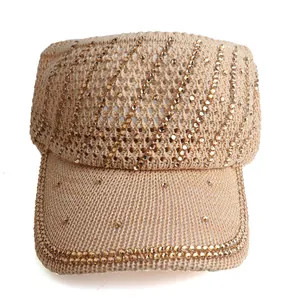 Macro detail of beige knit sun visor with elegant golden rhinestone wave patterns