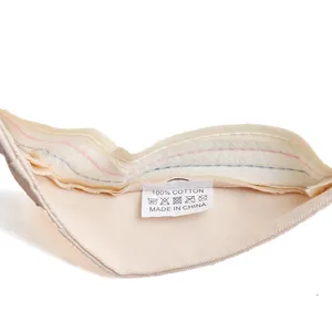 Détail de l'étiquette de lavage d'un chapeau 100% coton avec symboles d'entretien et matériel