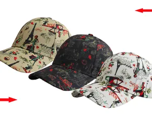 Detalle de tres gorras de béisbol con ilustraciones francesas y gráficos de la Torre Eiffel