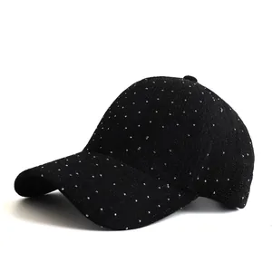 Détail d'une casquette de baseball noire avec des strass argentés et texture de tissu fine