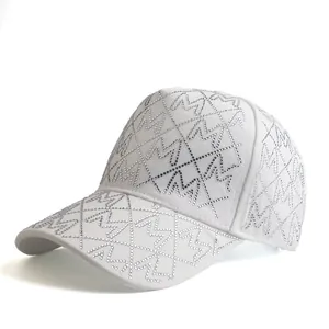 Macro detail of white baseball cap featuring sparkling M-shaped rhinestones in a grid pattern