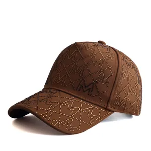 Detailed view of the brown baseball cap featuring M-shaped rhinestones and diamond stitching