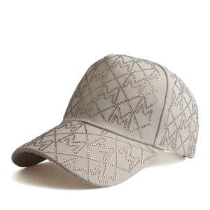 Detail of beige baseball cap featuring sparkling rhinestones and M letter pattern